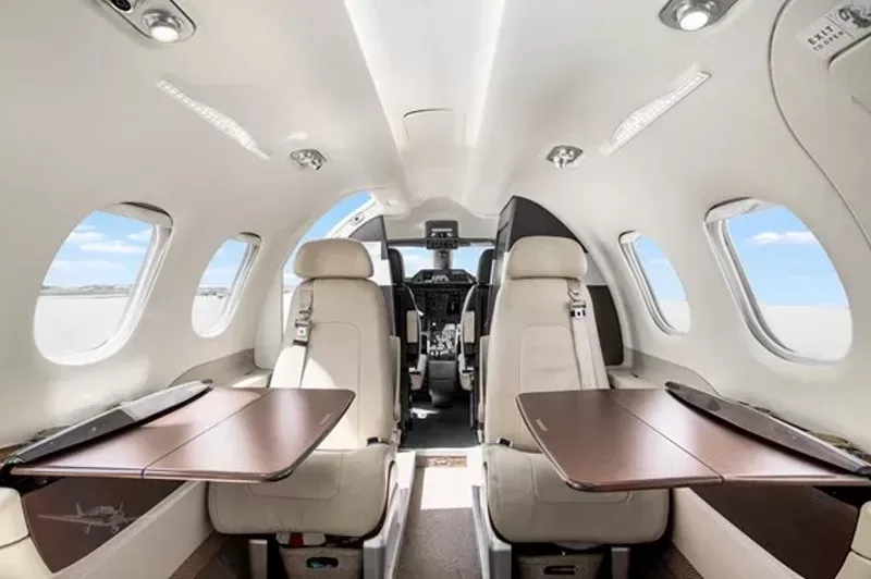 Comfortable and luxurious Embraer Phenom 100 seats for sale. View with tables deployed