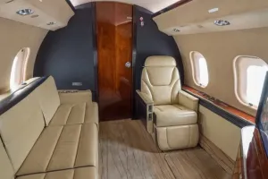 Mid cabin aisle view of 2007 Global XRS, showcasing spacious 13-passenger layout and beige carpet design